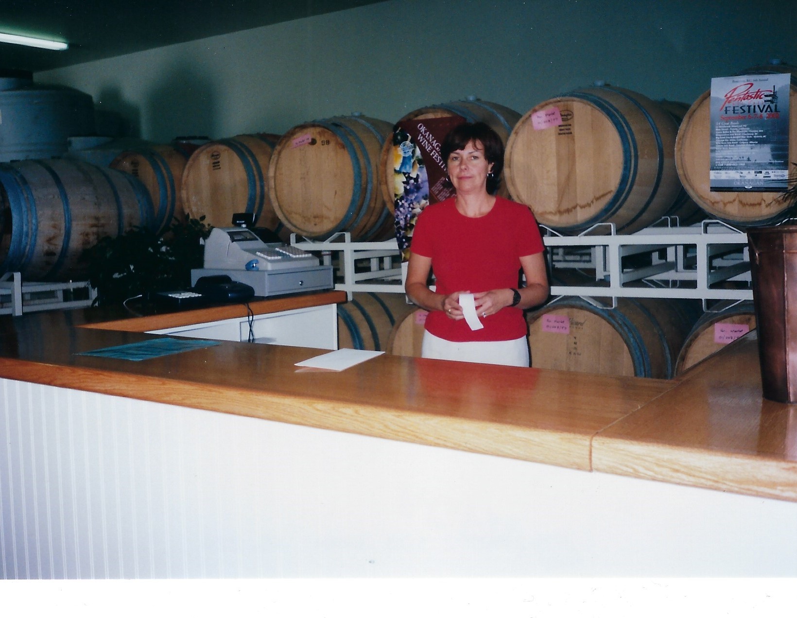 Niva Martin standing in front of wine barrels in the LA FRENZ tasting room.